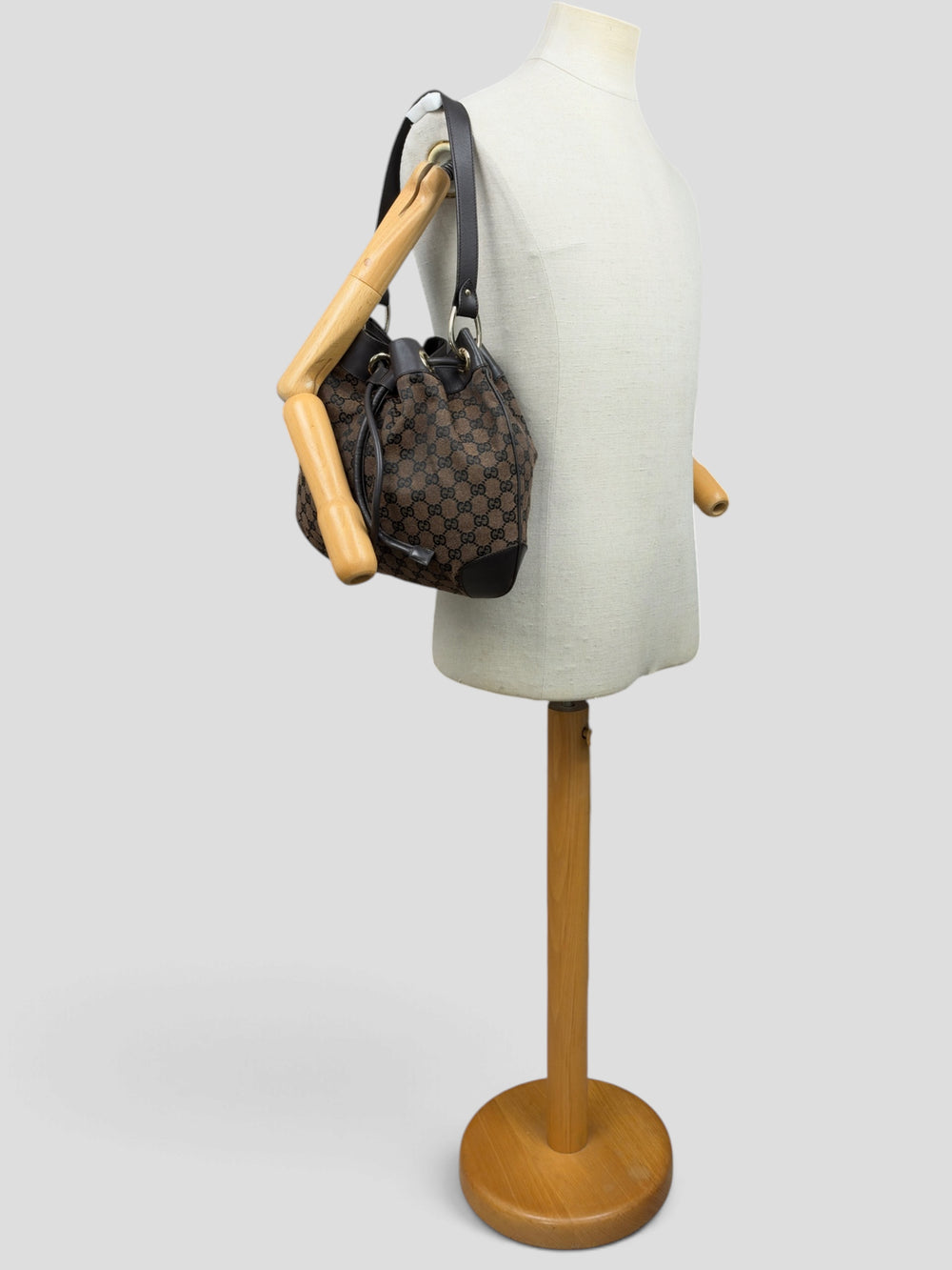 Gucci GG Canvas Drawstring Bucket Shoulder Bag in Braun/Schwarz, getragen an der Schneiderpuppe