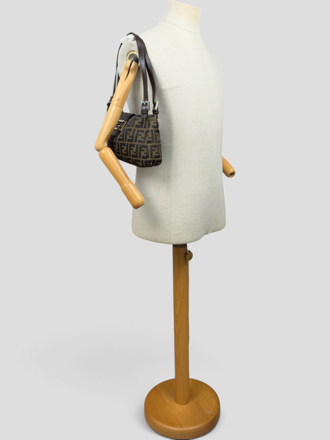 Fendi Zucca Canvas Baguette Buckle Shoulder Bag in Tabakbraun/Schwarz, getragen an der Schneiderpuppe