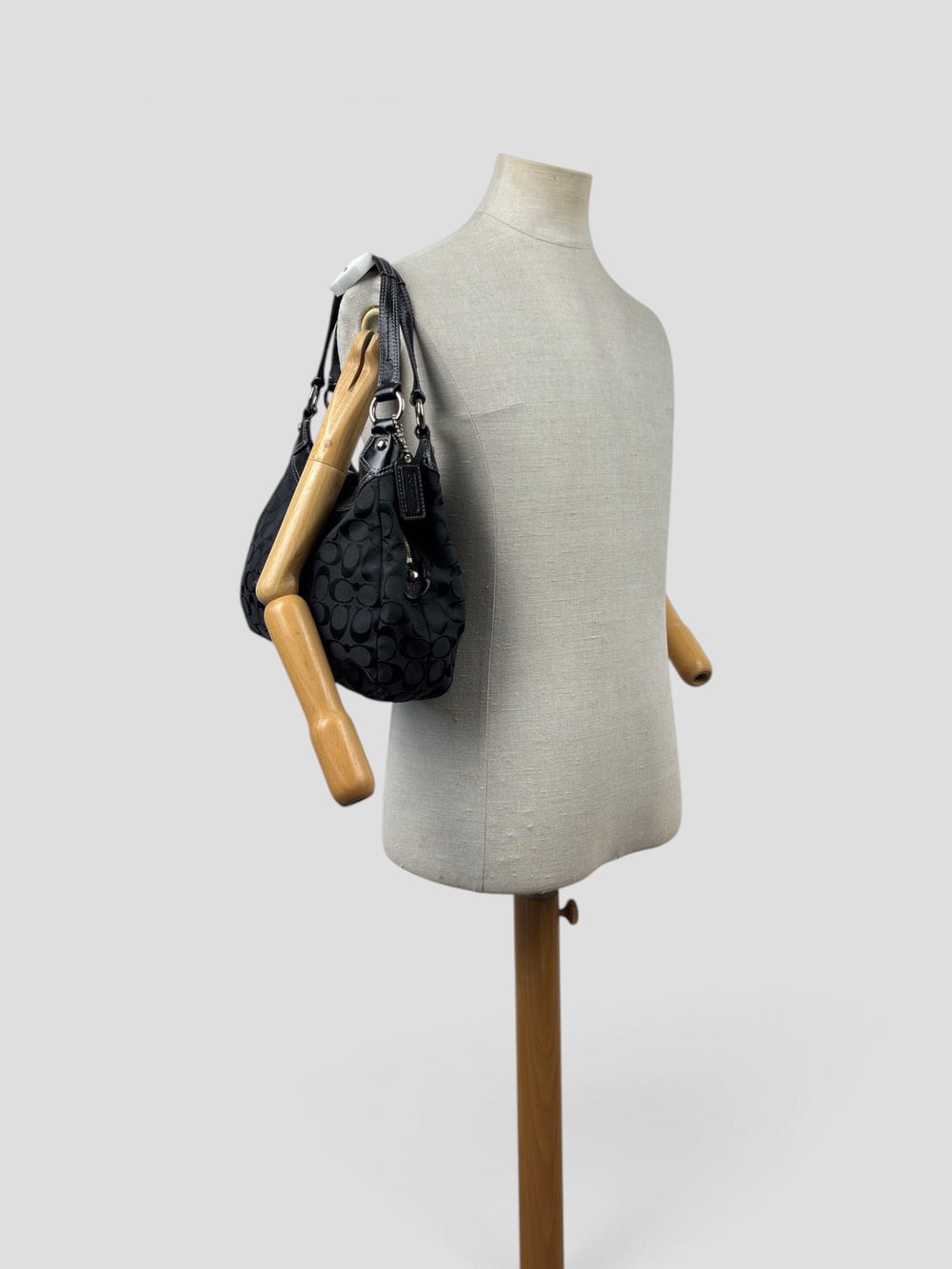 Coach Soho Signature Buckle Hobo Shoulder Bag in Schwarz/Anthrazit, getragen an der Schneiderpuppe