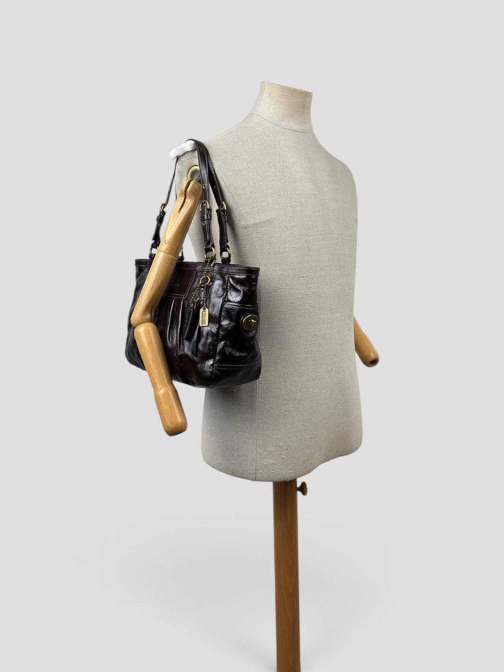 Coach Gallery Patent Leather Pleated Tote Shoulder Bag in Dunkelbraun, getragen an der Schneiderpuppe