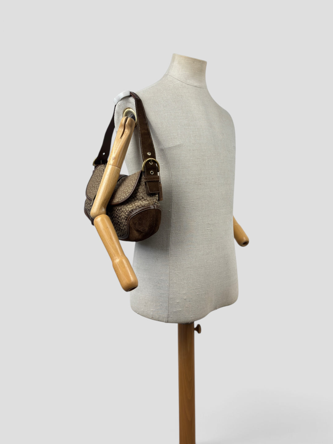 Coach Soho Mini Signature Suede Buckle Flap Shoulder Bag in Khaki/Braun, getragen an der Schneiderpuppe