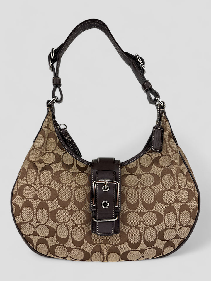 Coach Signature Strapbag mit beigem und braunem Logo-Muster, dunkelbraunen Lederdetails und einer Schnalle auf der Vorderseite. Verstellbare Schulterriemen für maximalen Komfort.