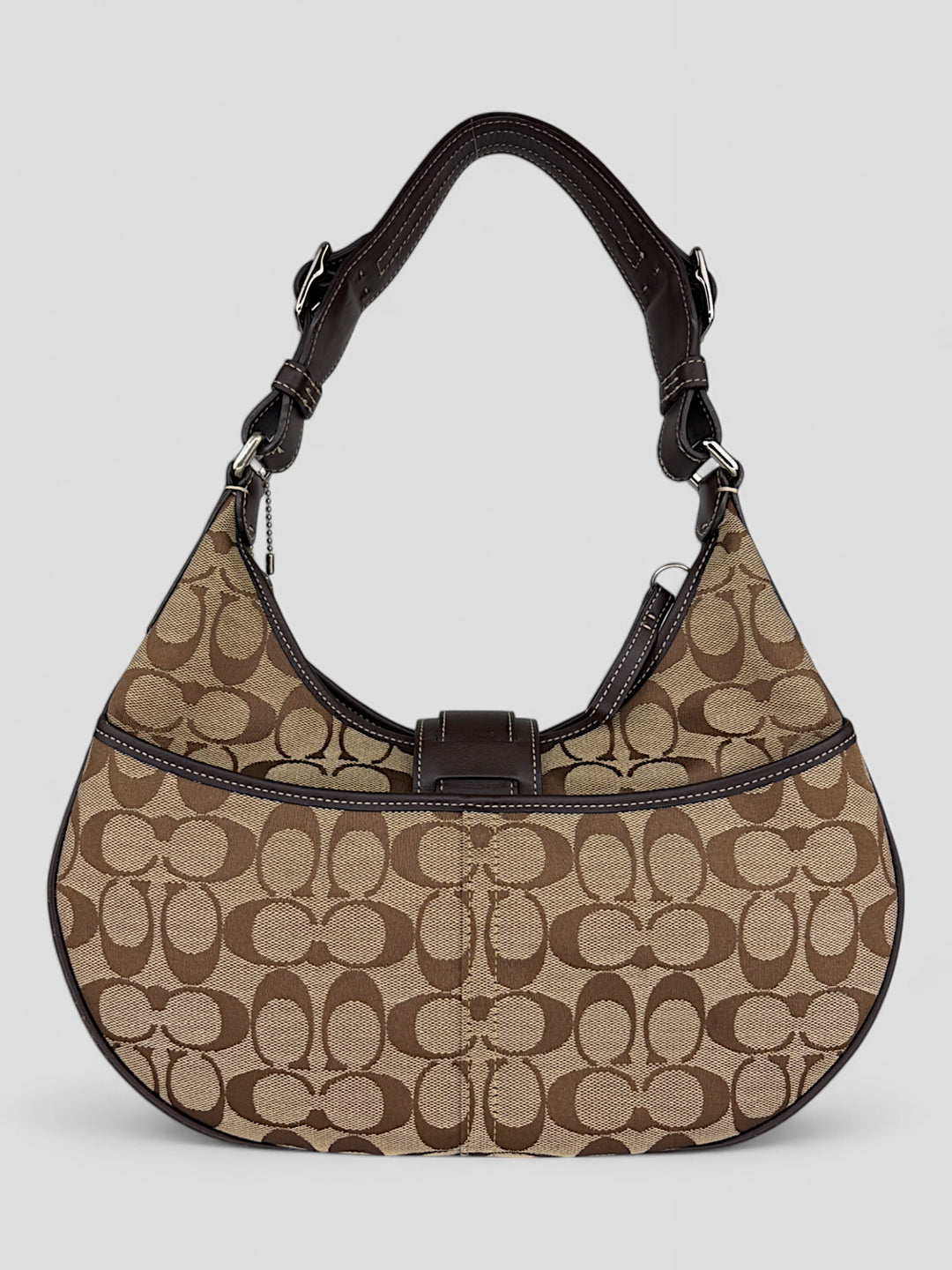 Coach Signature Strapbag mit beigem und braunem Logo-Muster, dunkelbraunen Lederdetails und einer Schnalle auf der Vorderseite. Verstellbare Schulterriemen für maximalen Komfort
