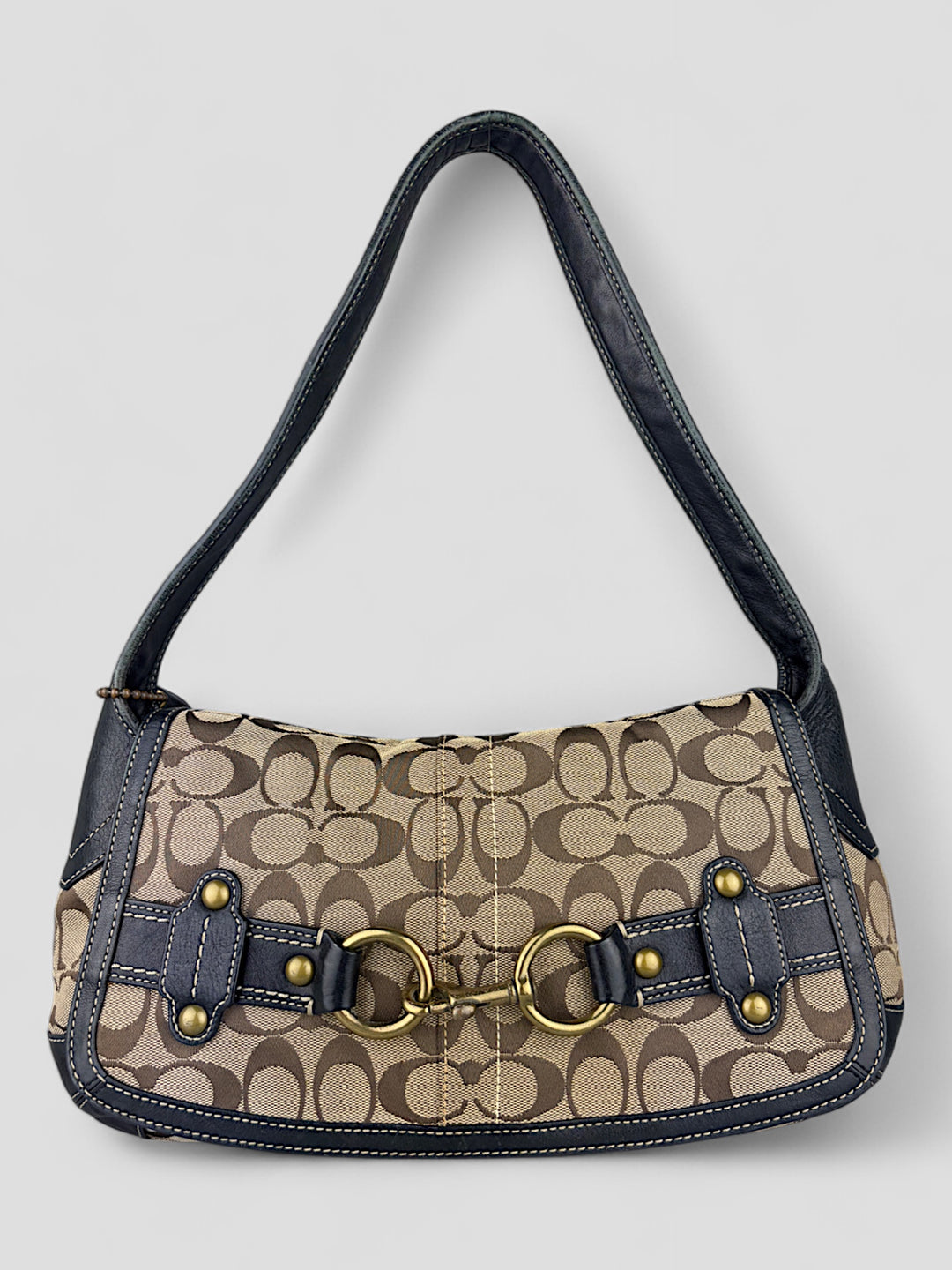 Coach Tasche mit beigem und braunem Logo-Muster, tiefschwarzen Lederdetails, goldfarbenen Beschlägen und einer markanten Schnalle. Stilvoll und luxuriös.