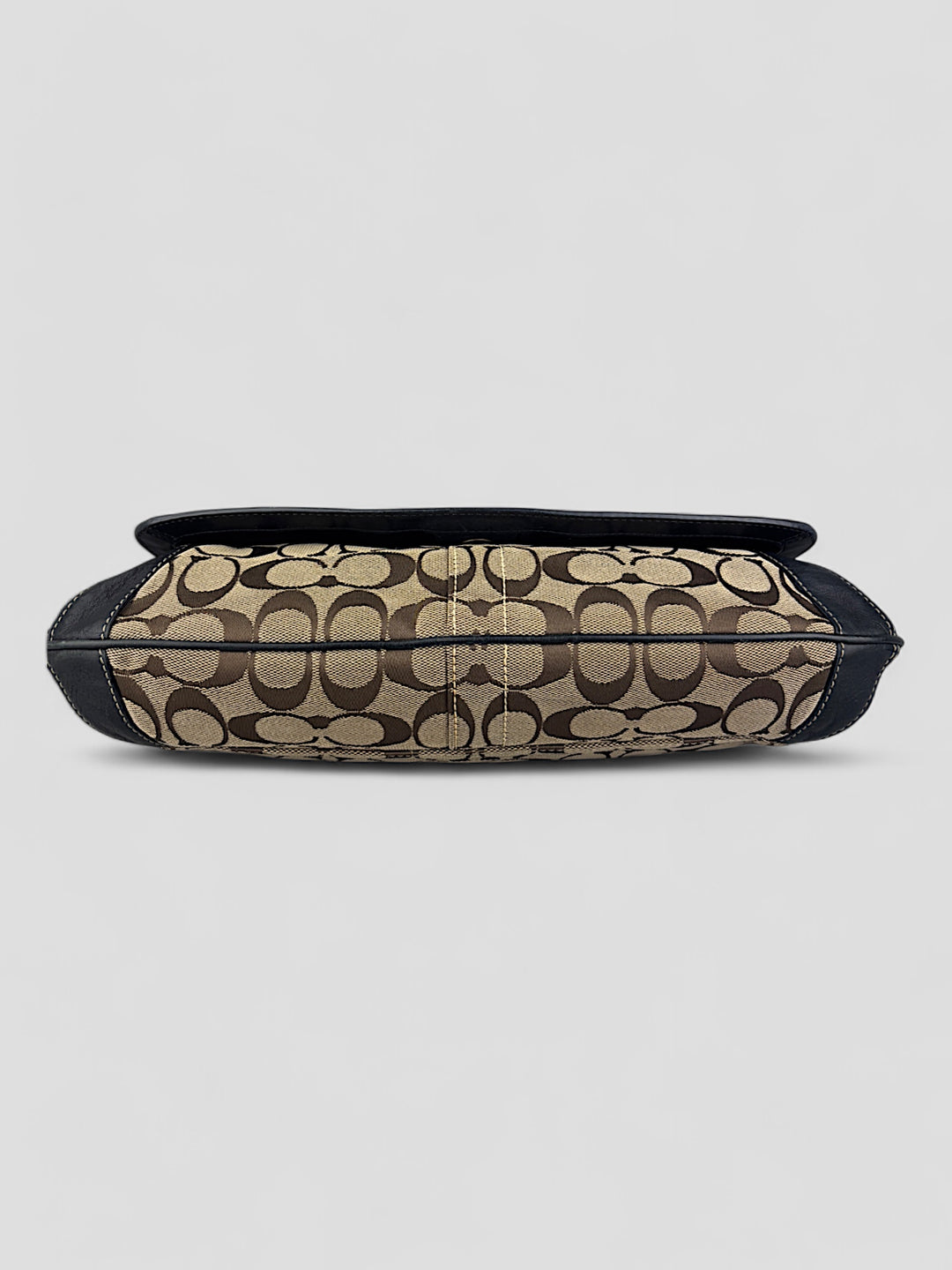 Coach Tasche mit beigem und braunem Logo-Muster, tiefschwarzen Lederdetails, goldfarbenen Beschlägen und einer markanten Schnalle. Stilvoll und luxuriös