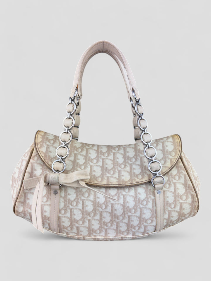 Dior Trotter Romantique Tasche mit beige-cremefarbenem Trotter-Print, silberfarbenen Kettengriffen und Schleifendetail auf der Vorderseite. Stilvoll und feminin.