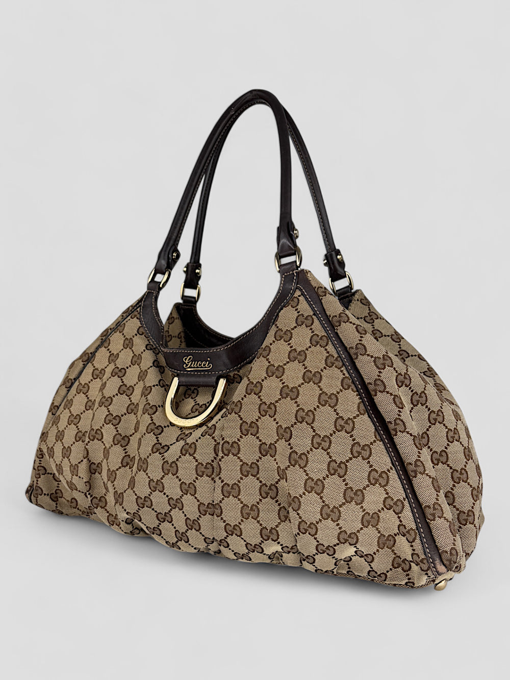 Gucci D-Ring Shoulderbag aus braunem GG-Canvas mit dunkelbraunen Lederdetails, goldfarbenem D-Ring und großzügigem Innenraum. Luxuriös und vielseitig