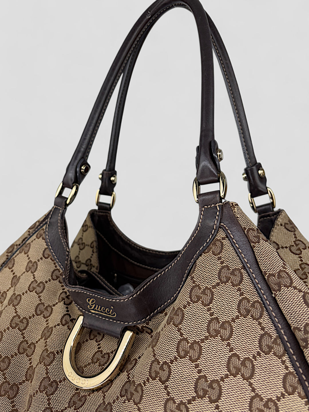 Gucci D-Ring Shoulderbag aus braunem GG-Canvas mit dunkelbraunen Lederdetails, goldfarbenem D-Ring und großzügigem Innenraum. Luxuriös und vielseitig