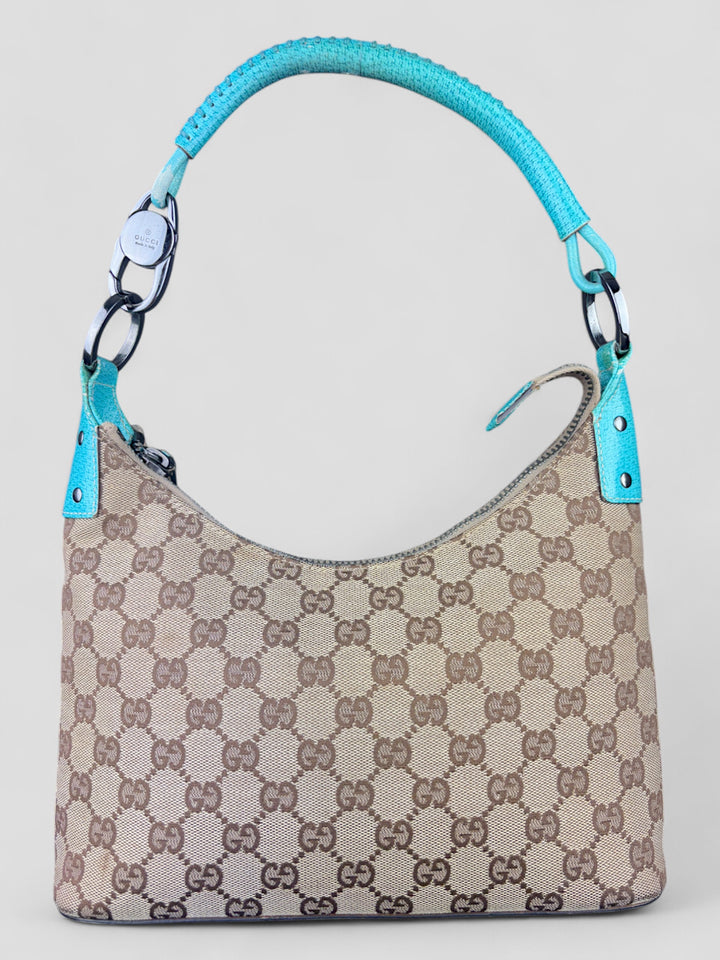 Gucci Hobo Tasche aus beigem Canvas mit GG-Muster, akzentuiert durch türkisfarbene Lederdetails und silberfarbene Metall-Elemente. Stilvoll und modern