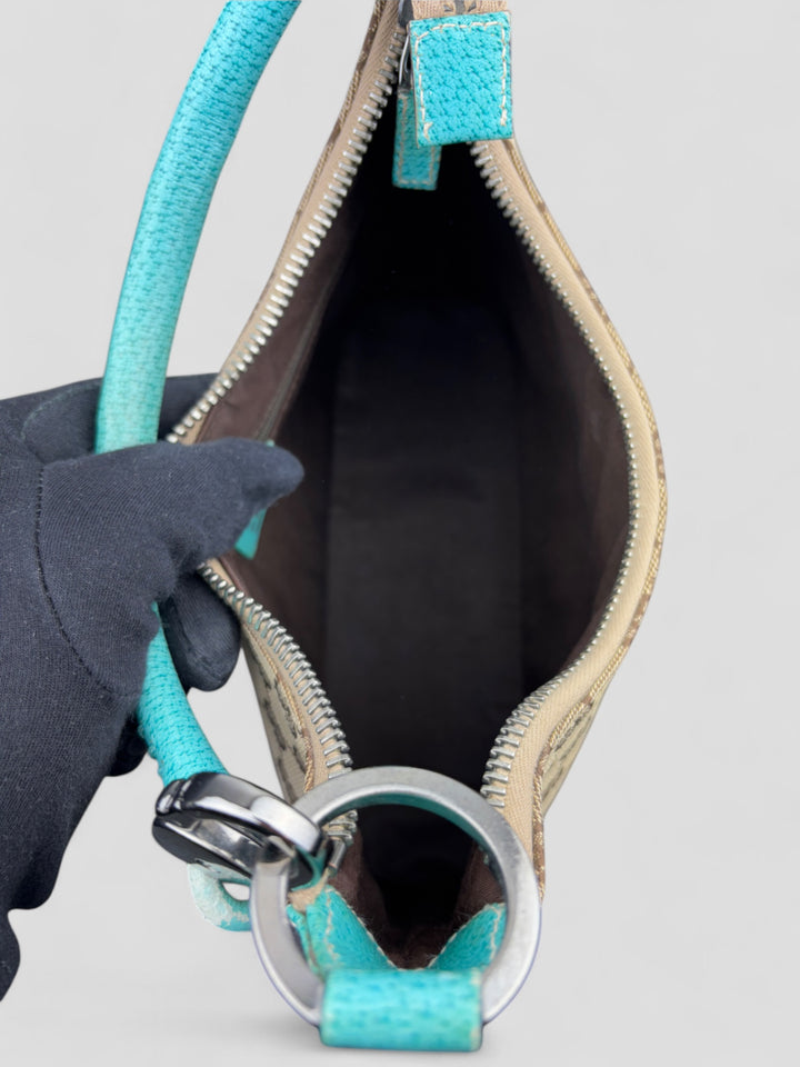 Gucci Hobo Tasche aus beigem Canvas mit GG-Muster, akzentuiert durch türkisfarbene Lederdetails und silberfarbene Metall-Elemente. Stilvoll und modern