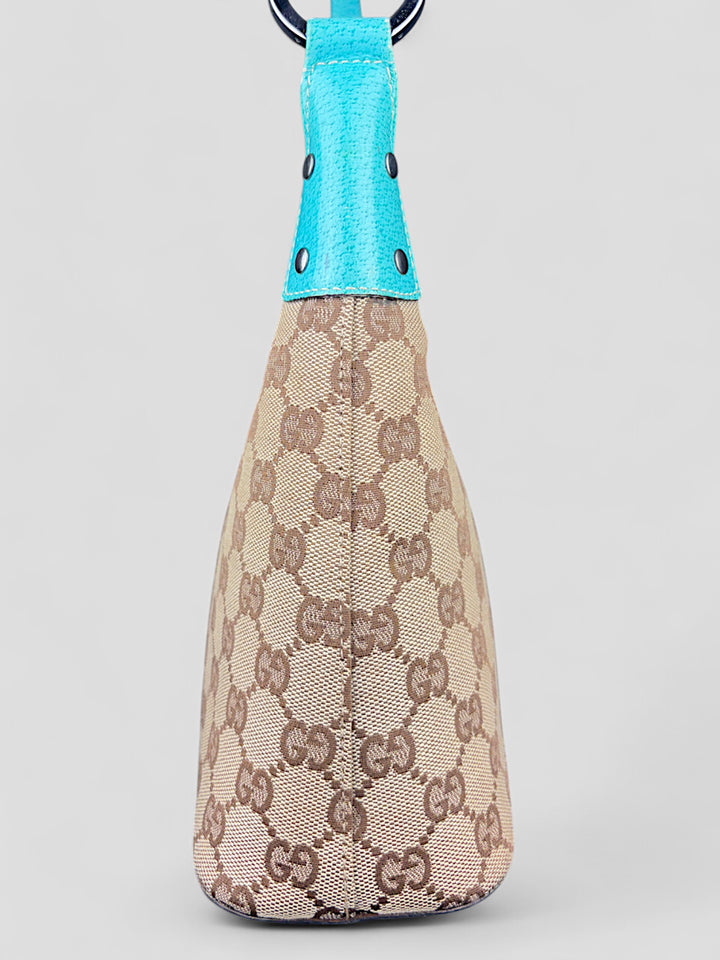 Gucci Hobo Tasche aus beigem Canvas mit GG-Muster, akzentuiert durch türkisfarbene Lederdetails und silberfarbene Metall-Elemente. Stilvoll und modern