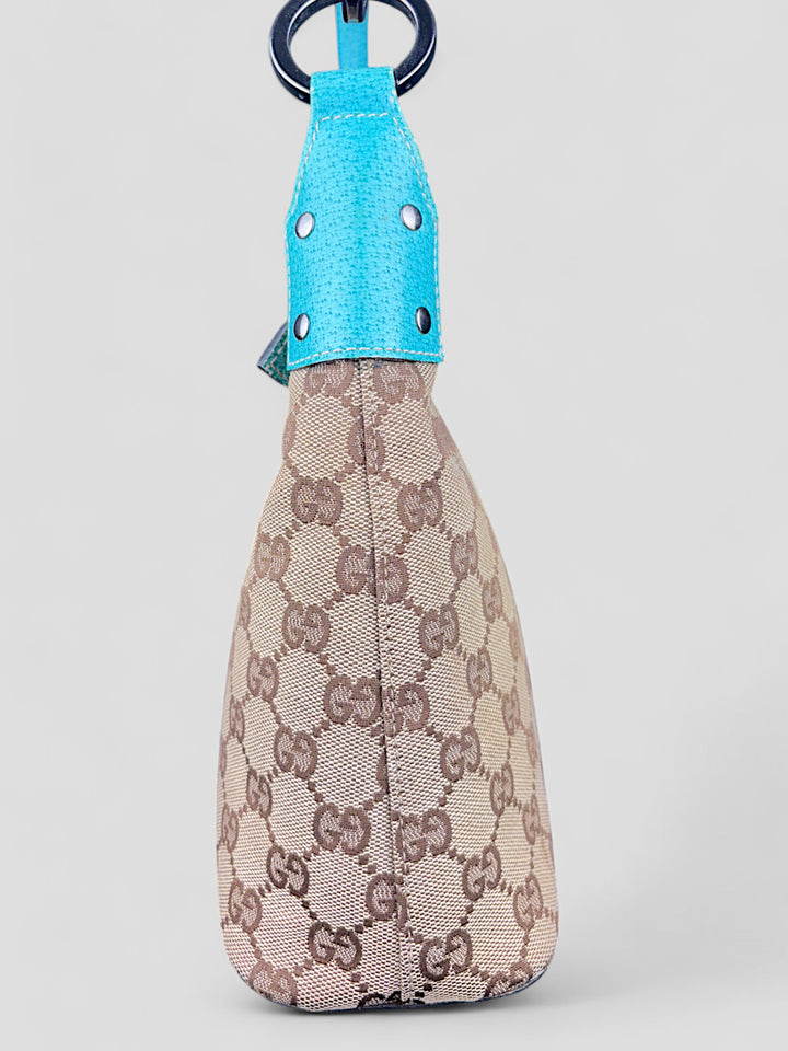 Gucci Hobo Tasche aus beigem Canvas mit GG-Muster, akzentuiert durch türkisfarbene Lederdetails und silberfarbene Metall-Elemente. Stilvoll und modern