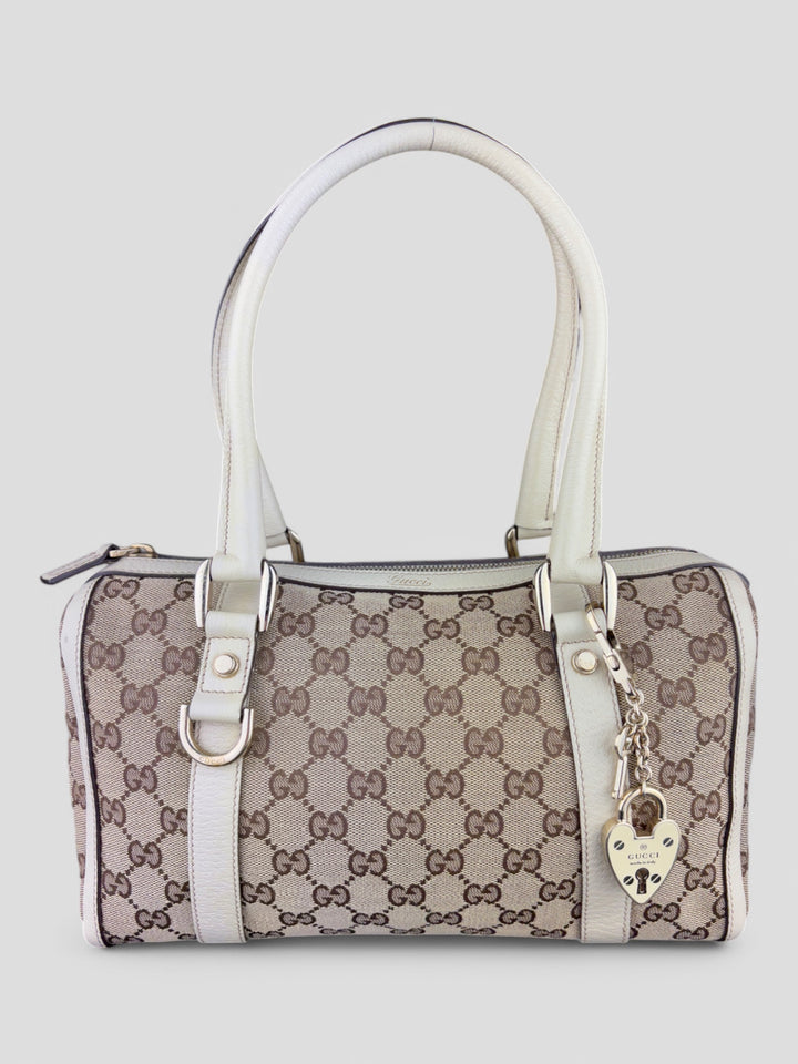 Gucci Schultertasche mit ikonischem Monogramm, weißen Lederdetails und Herzanhänger