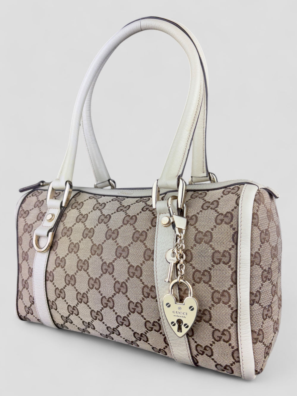 Gucci Schultertasche mit ikonischem Monogramm, weißen Lederdetails und Herzanhänger