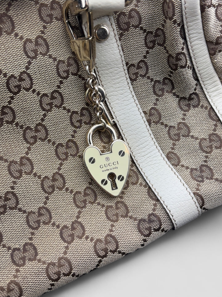 Gucci Schultertasche mit ikonischem Monogramm, weißen Lederdetails und Herzanhänger