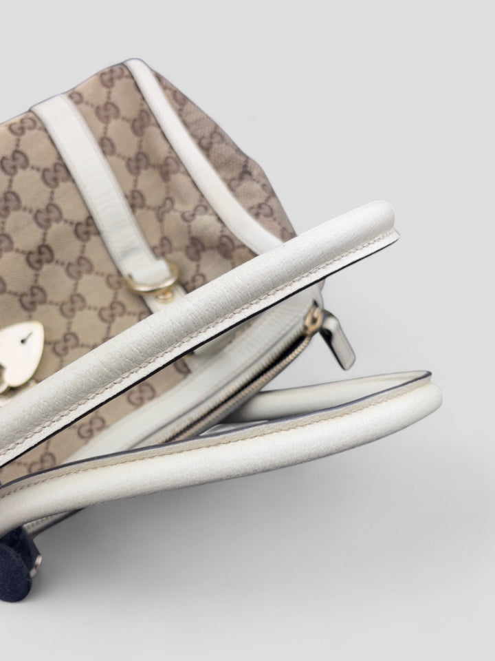 Gucci Schultertasche mit ikonischem Monogramm, weißen Lederdetails und Herzanhänger