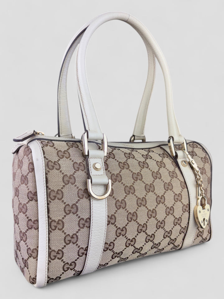 Gucci Schultertasche mit ikonischem Monogramm, weißen Lederdetails und Herzanhänger