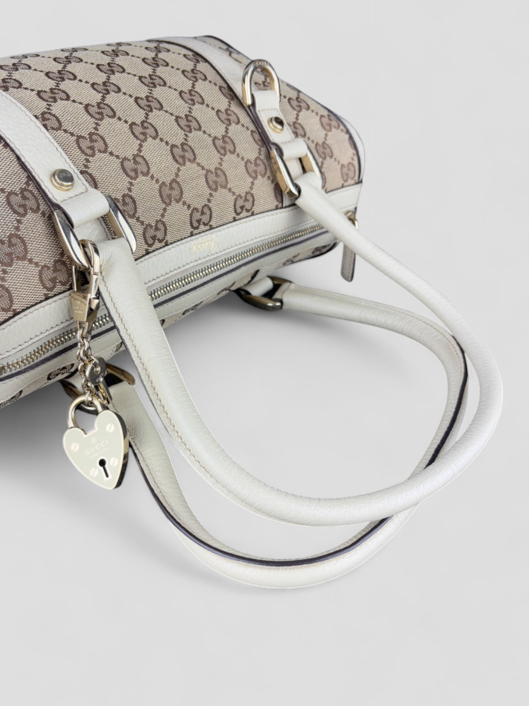 Gucci Schultertasche mit ikonischem Monogramm, weißen Lederdetails und Herzanhänger