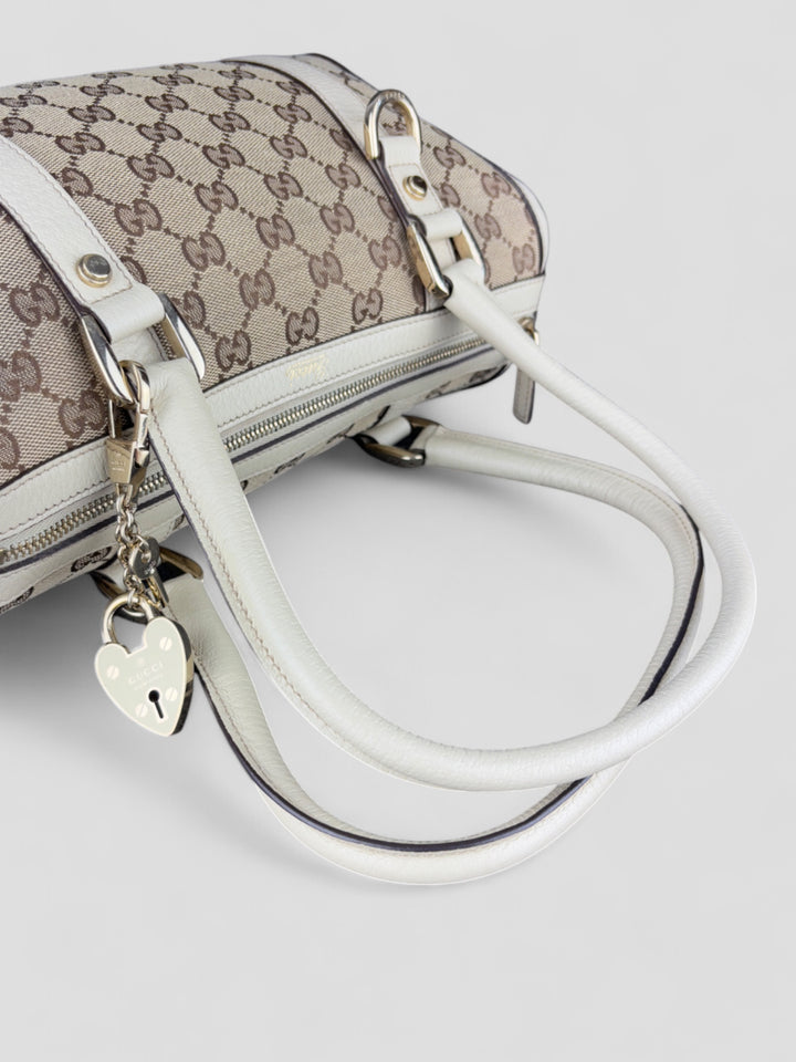 Gucci Schultertasche mit ikonischem Monogramm, weißen Lederdetails und Herzanhänger