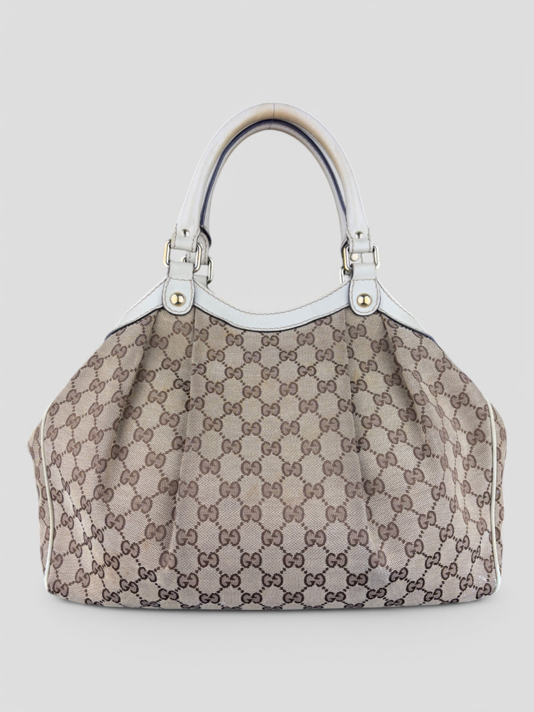 Gucci Sukey Tasche aus cremefarbenem GG-Canvas, ergänzt durch hochwertige Lederdetails und einen abnehmbaren Gucci-Anhänger