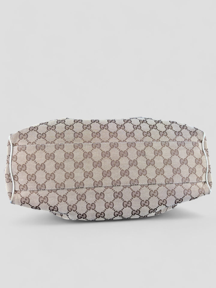 Gucci Sukey Tasche aus cremefarbenem GG-Canvas, ergänzt durch hochwertige Lederdetails und einen abnehmbaren Gucci-Anhänger