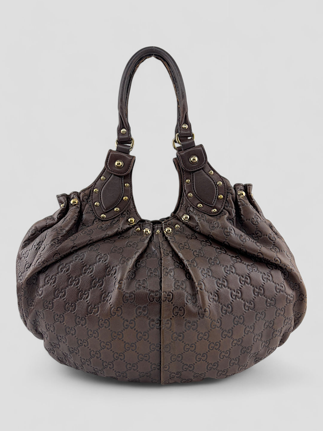 Gucci Sukey Tasche aus schokoladenbraunem Leder mit dezent eingeprägtem GG-Muster, goldfarbenen Nieten und raffiniertem Design. Elegant und geräumig