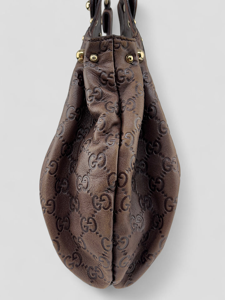 Gucci Sukey Tasche aus schokoladenbraunem Leder mit dezent eingeprägtem GG-Muster, goldfarbenen Nieten und raffiniertem Design. Elegant und geräumig