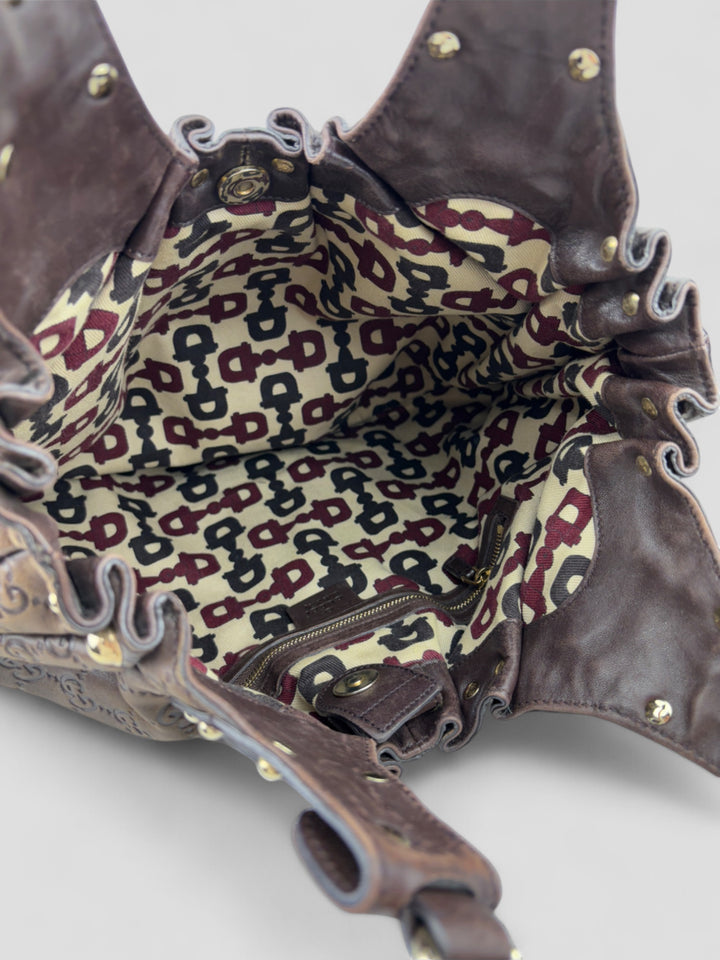 Gucci Sukey Tasche aus schokoladenbraunem Leder mit dezent eingeprägtem GG-Muster, goldfarbenen Nieten und raffiniertem Design. Elegant und geräumig