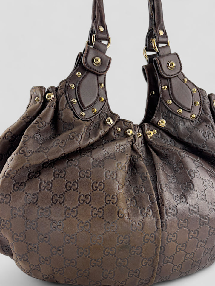 Gucci Sukey Tasche aus schokoladenbraunem Leder mit dezent eingeprägtem GG-Muster, goldfarbenen Nieten und raffiniertem Design. Elegant und geräumig