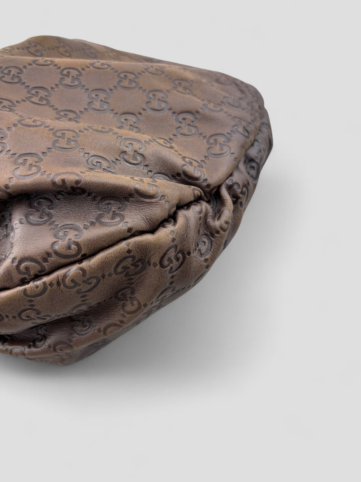Gucci Sukey Tasche aus schokoladenbraunem Leder mit dezent eingeprägtem GG-Muster, goldfarbenen Nieten und raffiniertem Design. Elegant und geräumig