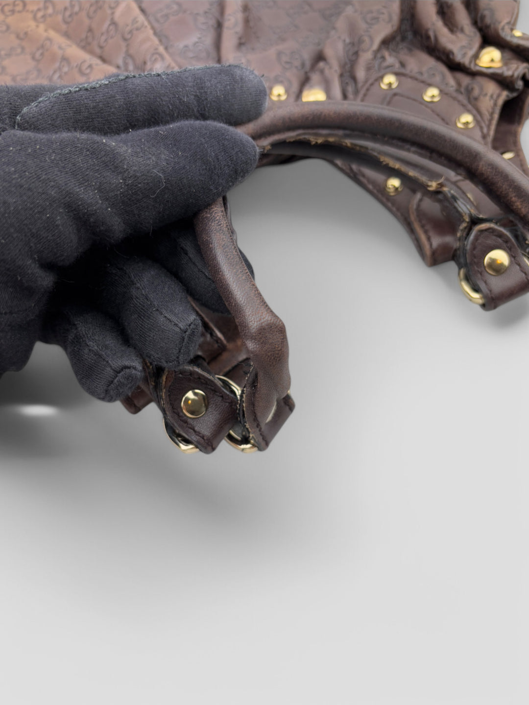 Gucci Sukey Tasche aus schokoladenbraunem Leder mit dezent eingeprägtem GG-Muster, goldfarbenen Nieten und raffiniertem Design. Elegant und geräumig