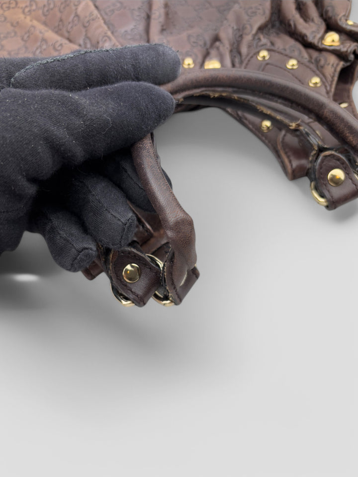Gucci Sukey Tasche aus schokoladenbraunem Leder mit dezent eingeprägtem GG-Muster, goldfarbenen Nieten und raffiniertem Design. Elegant und geräumig