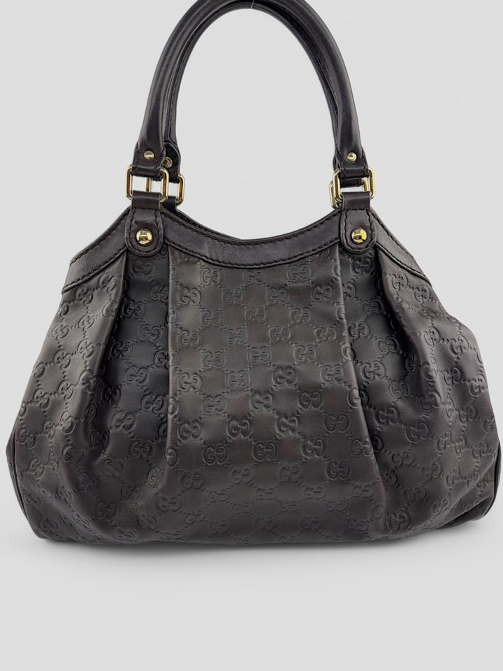Gucci Sukkey Tasche aus geprägtem schwarzem Leder mit charakteristischem Gucci-Monogramm, Gucci Sukkey bag made of embossed black leather with iconic Gucci monogram