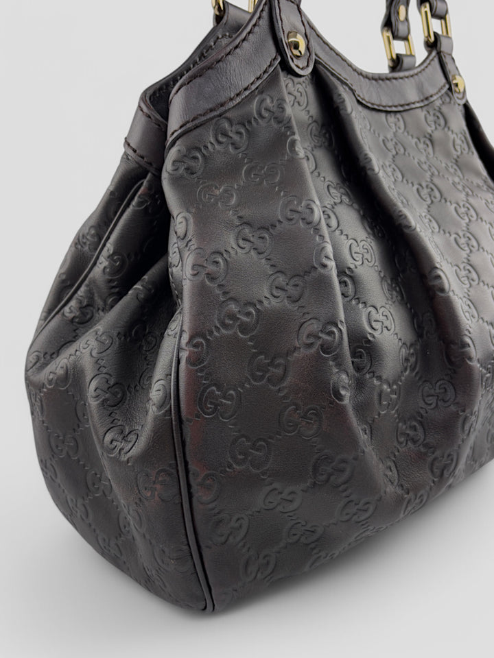 Gucci Sukkey Tasche aus geprägtem schwarzem Leder mit charakteristischem Gucci-Monogramm, Gucci Sukkey bag made of embossed black leather with iconic Gucci monogram