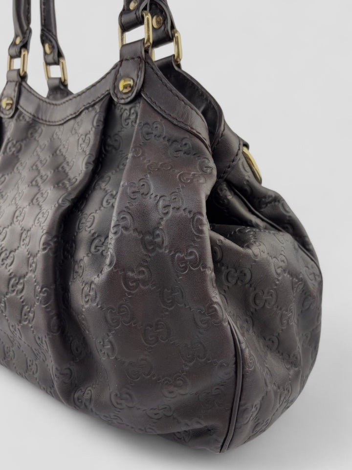 Gucci Sukkey Tasche aus geprägtem schwarzem Leder mit charakteristischem Gucci-Monogramm, Gucci Sukkey bag made of embossed black leather with iconic Gucci monogram