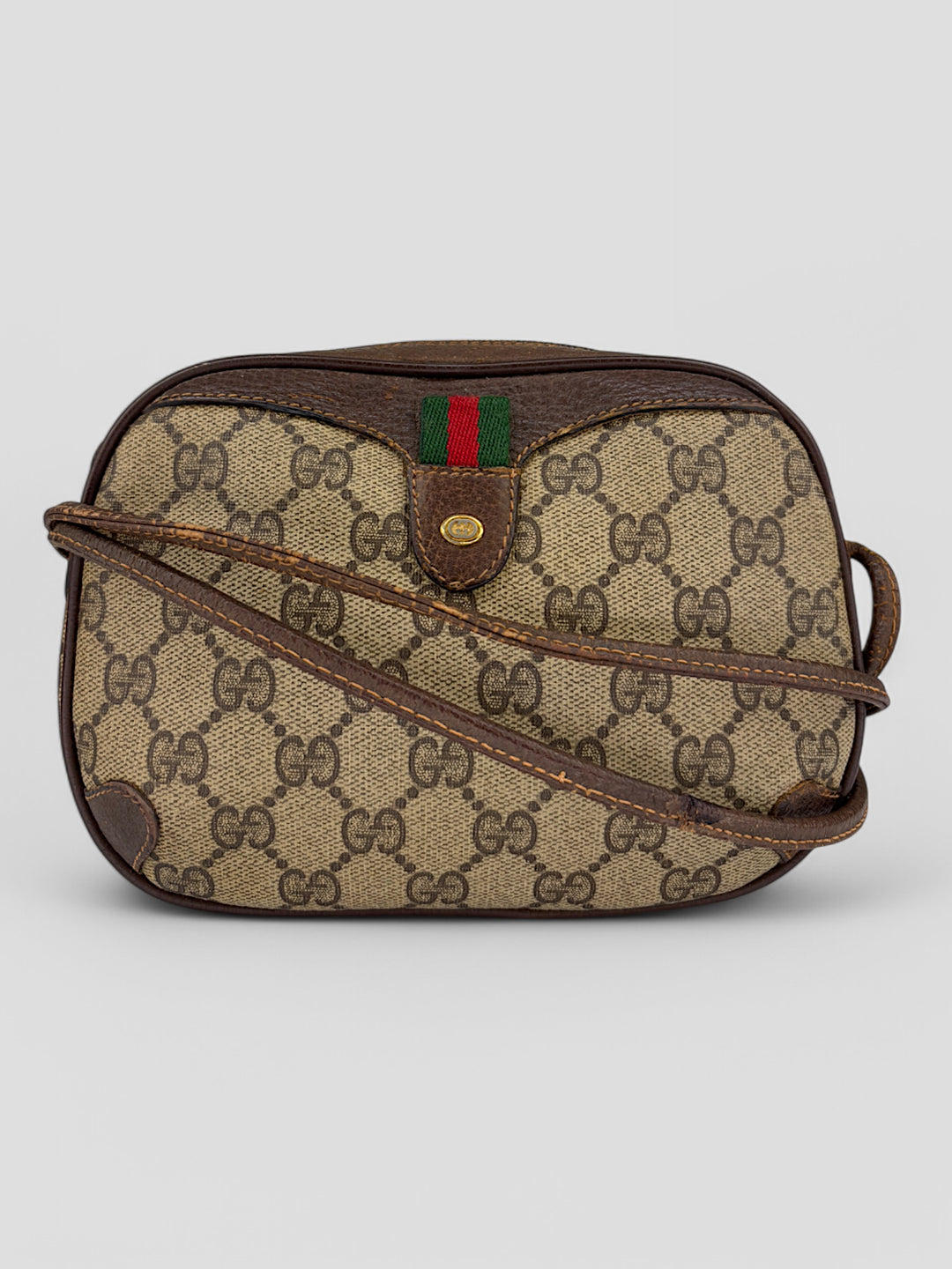 Gucci Vintage Herren Tasche aus beigem GG-Canvas mit braunen Lederakzenten und grün-rotem Webdetail. Kompakt und stilvoll.