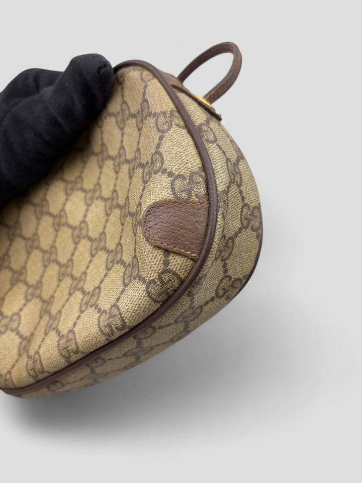 Gucci Vintage Herren Tasche aus beigem GG-Canvas mit braunen Lederakzenten und grün-rotem Webdetail. Kompakt und stilvoll