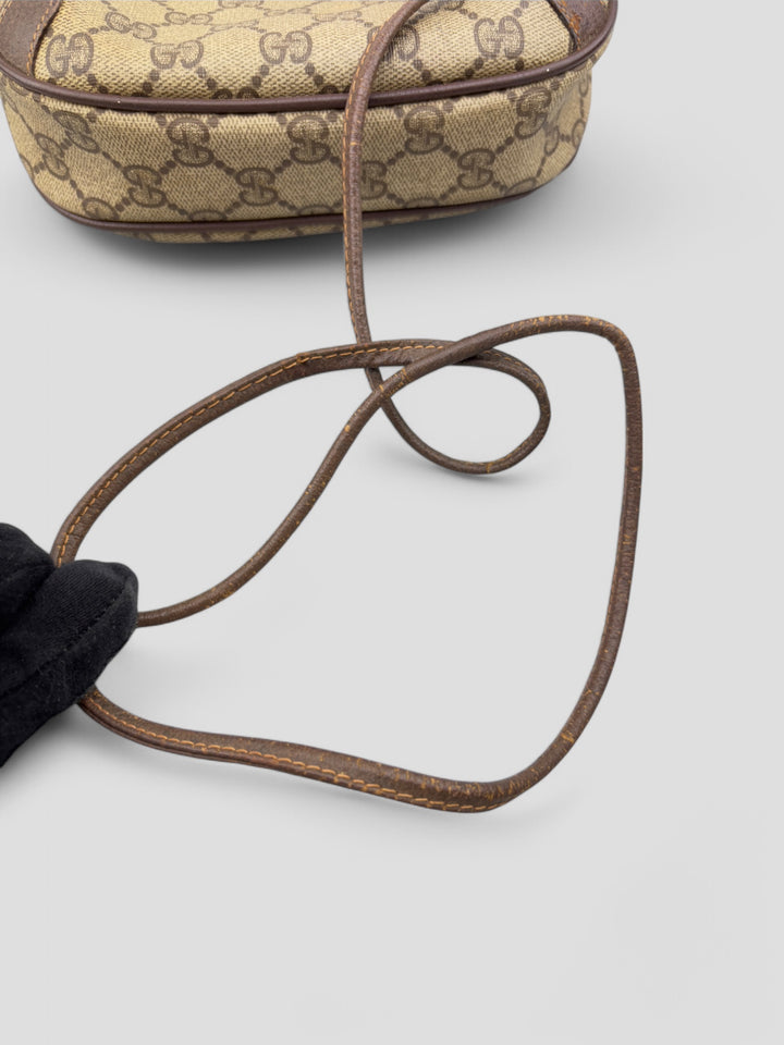 Gucci Vintage Herren Tasche aus beigem GG-Canvas mit braunen Lederakzenten und grün-rotem Webdetail. Kompakt und stilvoll