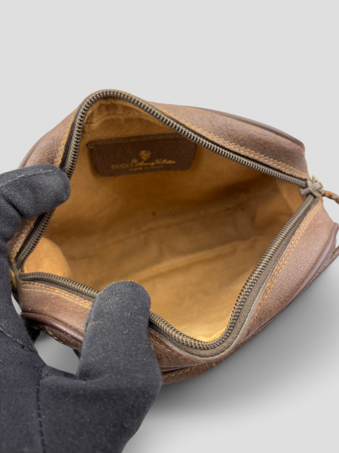 Gucci Vintage Herren Tasche aus beigem GG-Canvas mit braunen Lederakzenten und grün-rotem Webdetail. Kompakt und stilvoll
