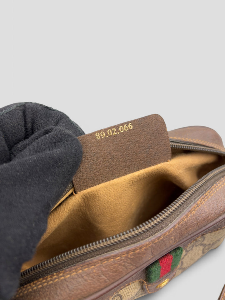 Gucci Vintage Herren Tasche aus beigem GG-Canvas mit braunen Lederakzenten und grün-rotem Webdetail. Kompakt und stilvoll