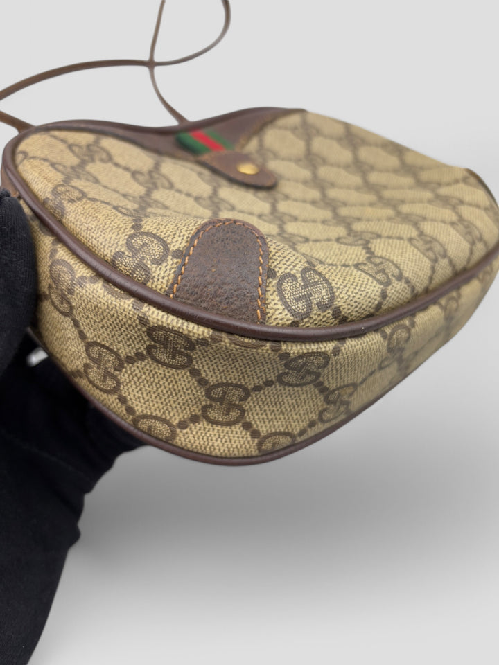 Gucci Vintage Herren Tasche aus beigem GG-Canvas mit braunen Lederakzenten und grün-rotem Webdetail. Kompakt und stilvoll