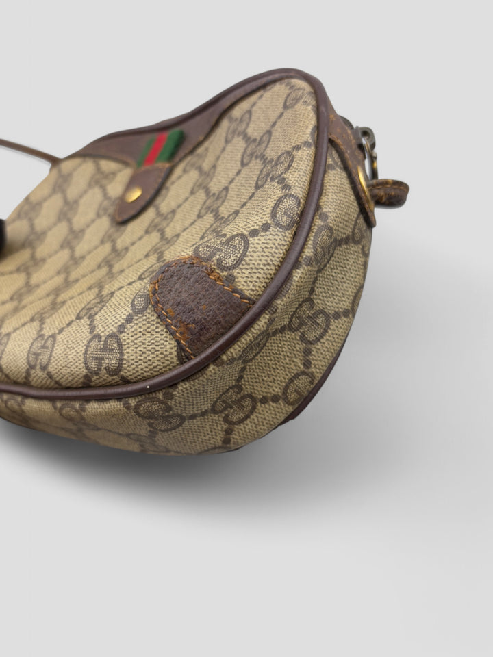 Gucci Vintage Herren Tasche aus beigem GG-Canvas mit braunen Lederakzenten und grün-rotem Webdetail. Kompakt und stilvoll