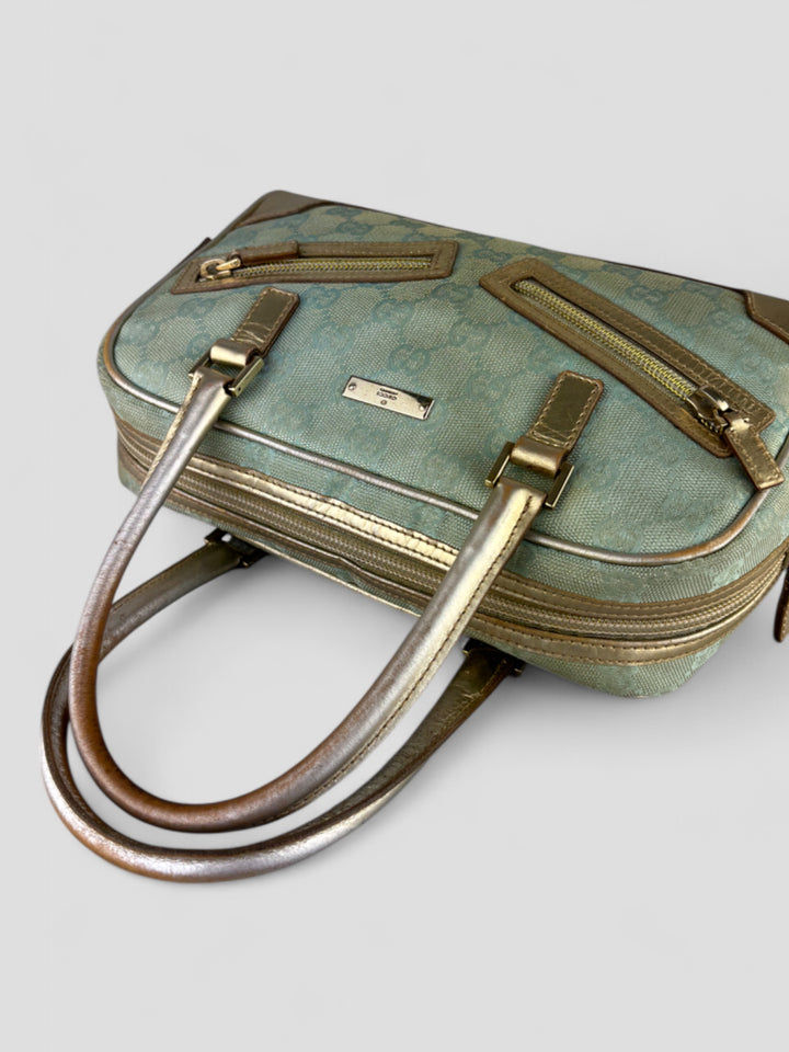 Gucci Vintage Tasche aus hellblauem Canvas mit goldfarbenen Akzenten und zwei markanten Reißverschlusstaschen auf der Vorderseite