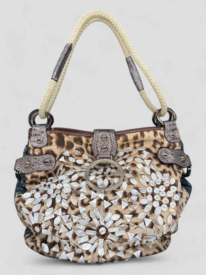 Guess Jeans Flower Sack Schultertasche mit Denim-Look, Leopardenmuster, aufwendigen Perlendetails in Blütenform und geflochtenen Henkeln.