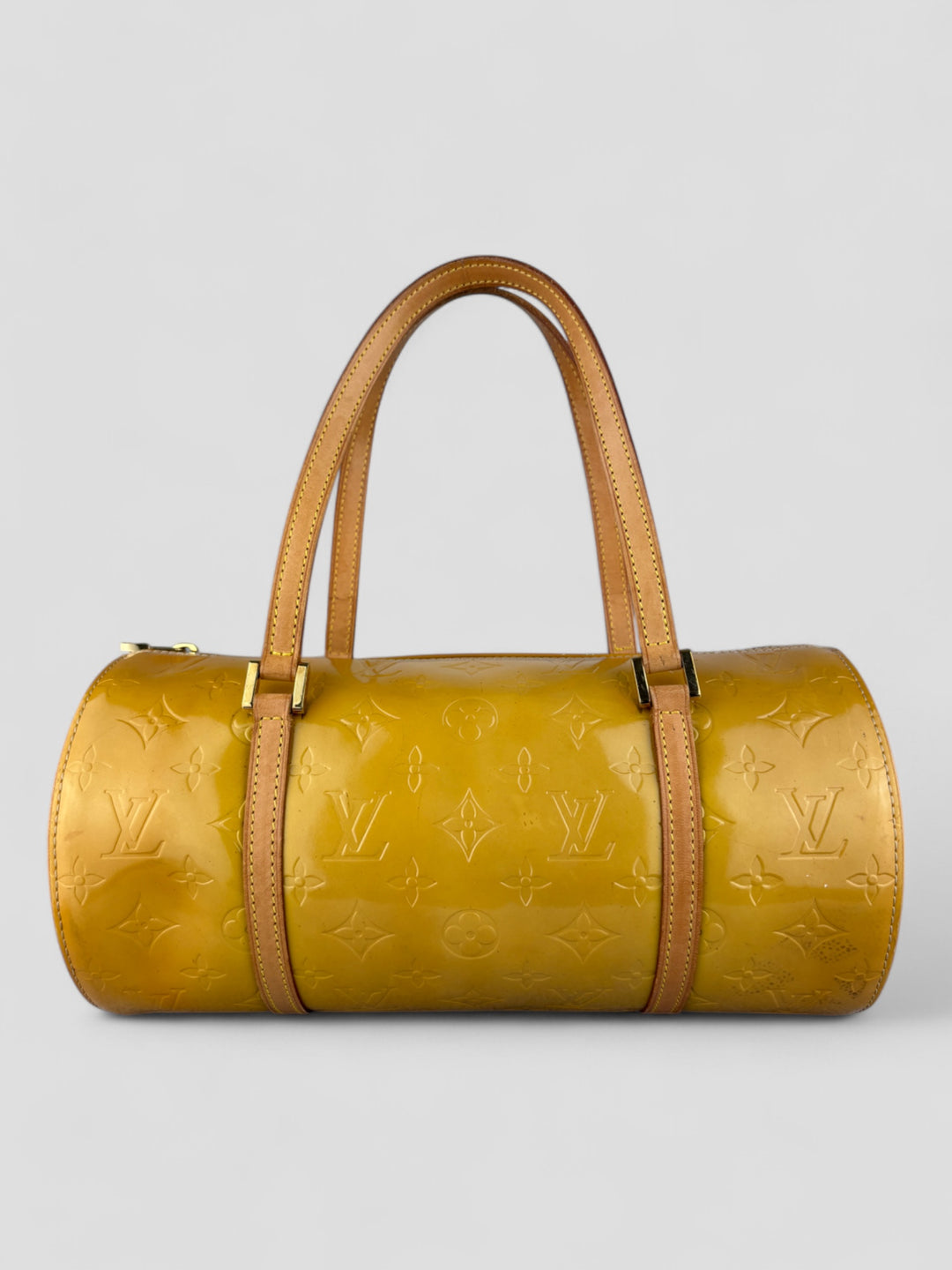 Louis Vuitton Papillon Tasche aus gelbem Lackleder mit glänzendem Finish, goldfarbenen Beschlägen und einer klassischen zylindrischen Form. Stilvoll und auffällig