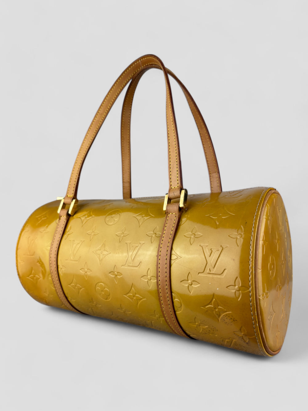 Louis Vuitton Papillon Tasche aus gelbem Lackleder mit glänzendem Finish, goldfarbenen Beschlägen und einer klassischen zylindrischen Form. Stilvoll und auffällig