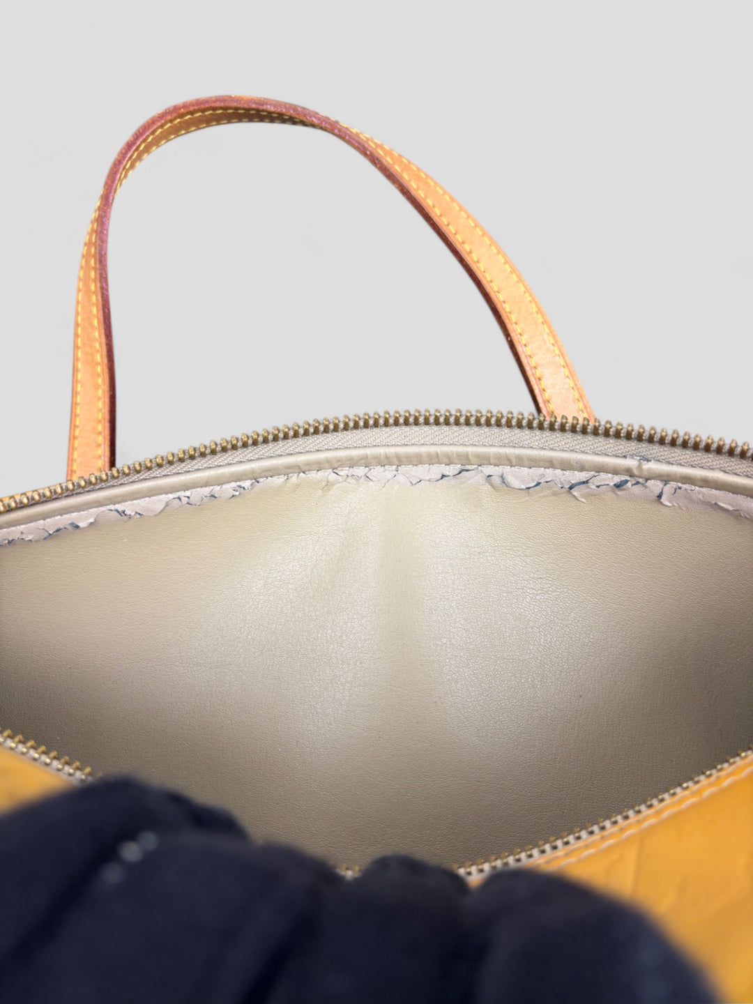 Louis Vuitton Papillon Tasche aus gelbem Lackleder mit glänzendem Finish, goldfarbenen Beschlägen und einer klassischen zylindrischen Form. Stilvoll und auffällig