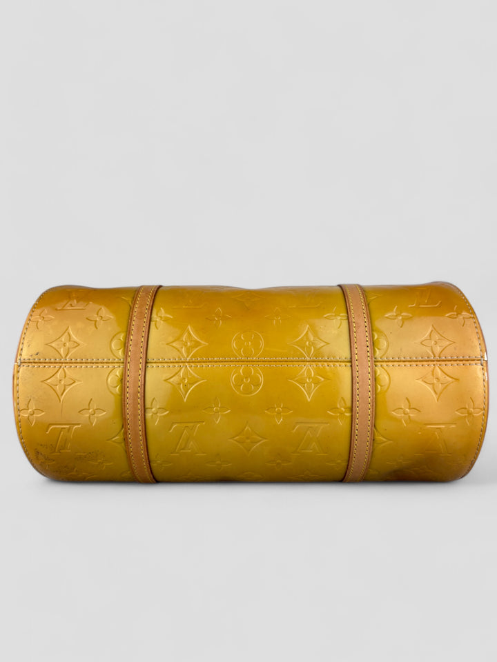 Louis Vuitton Papillon Tasche aus gelbem Lackleder mit glänzendem Finish, goldfarbenen Beschlägen und einer klassischen zylindrischen Form. Stilvoll und auffällig
