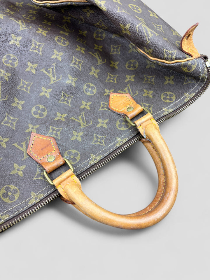 Louis Vuitton Speedy Reisetasche aus Monogramm-Canvas in Braun mit goldfarbenen Beschlägen und Lederdetails. Geräumig und stilvoll