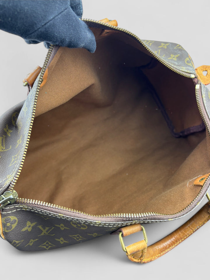 Louis Vuitton Speedy Reisetasche aus Monogramm-Canvas in Braun mit goldfarbenen Beschlägen und Lederdetails. Geräumig und stilvoll